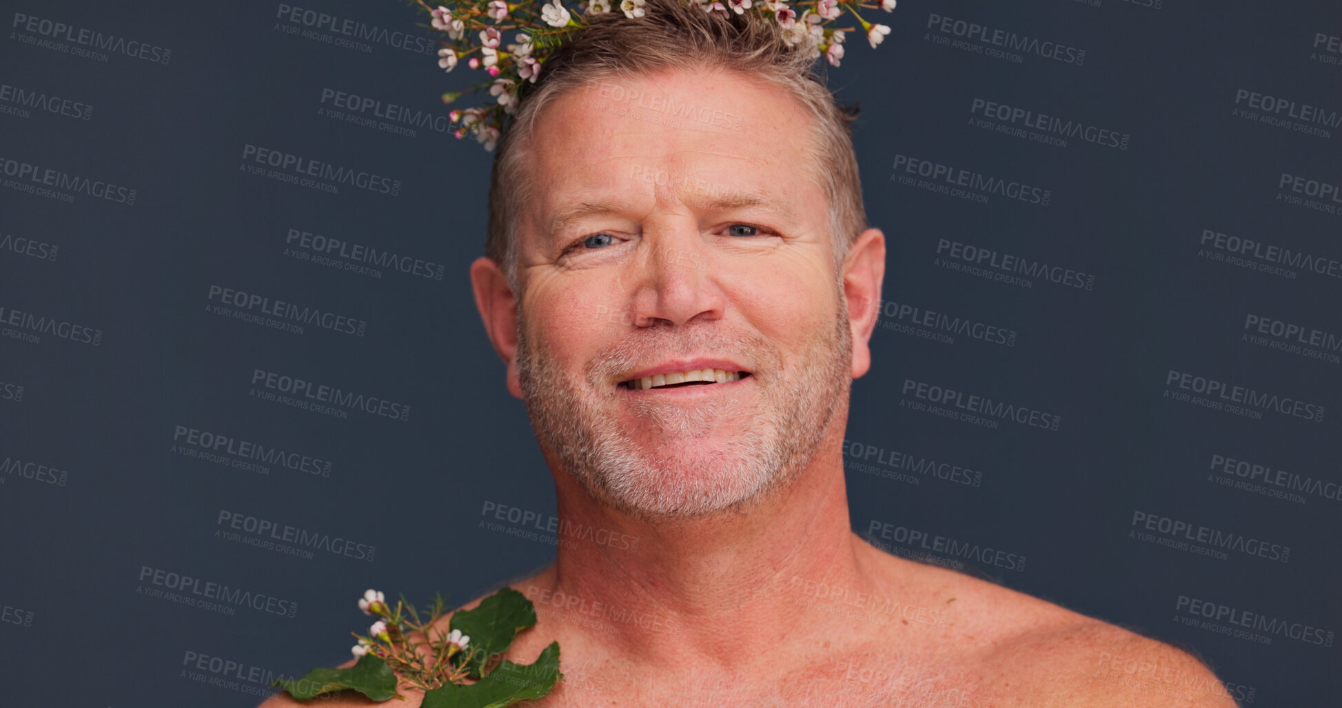 Buy stock photo Beauty, flower crown and portrait of mature man in studio on dark background for natural skincare. Cosmetics, dermatology and smile with gay or queer person in floral wreath for antiaging wellness