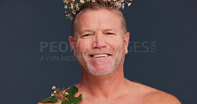 Buy stock photo Beauty, flower crown and portrait of queer man in studio on dark background for natural skincare. Cosmetics, dermatology and smile with mature gay person in floral wreath for antiaging wellness
