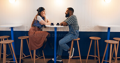 Buy stock photo Interracial couple, relax and talking with cup at coffee shop for bonding, romance or date together. Man, woman or lovers with smile for conversation, chat or social on table or chair at indoor cafe