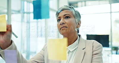 Buy stock photo Glass wall, writing and mature woman in office for planning, brainstorming or research for creative project. Journalism, thinking and female magazine editor work on media report for startup business.