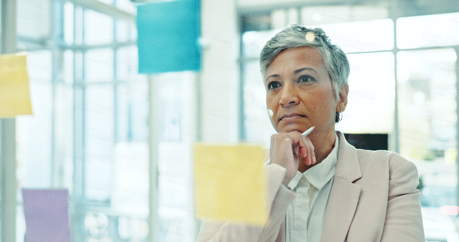 Buy stock photo Thinking, glass wall and mature businesswoman with creative planning with notes in office for project. Brainstorming, board and female event designer work on startup ideas for research in workplace.