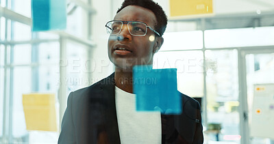 Buy stock photo Research, glass wall and businessman with creative planning with notes in office for project. Brainstorming, board and African male event designer work on startup ideas for development in workplace.