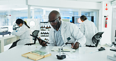 Buy stock photo Black man, scientist and tablet at notebook laboratory for research on medical or clinical study and investigation. Male person, employee and science with information for drug trial results or report