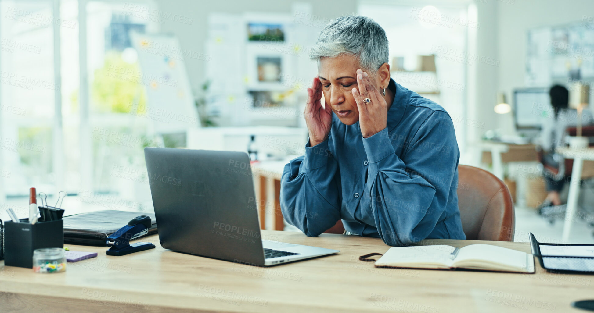 Buy stock photo Mature, frustrated woman or headache with laptop for stress, deadline or strain at office desk. Senior, female person or migraine with anxiety, debt or bankruptcy for pain, vertigo or dizziness