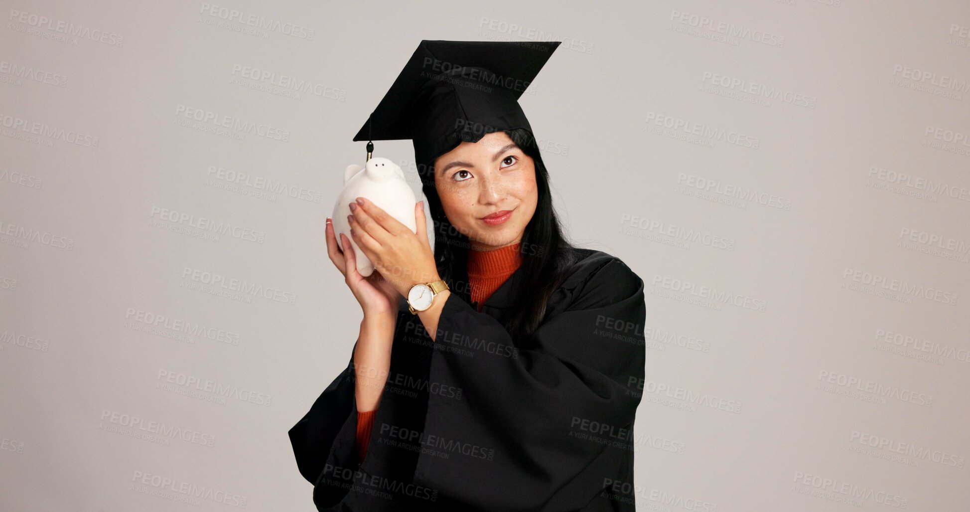 Buy stock photo Woman, graduation and think with piggy bank in studio background for savings, financial aid or investment. Asian person, portrait and ideas with money or funds for tuition fees and higher education