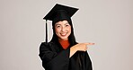 Woman, studio and university student with pointing on  graduation for career advice, instructions and tips. Asian person, portrait and happy in confidence for education and scholarship opportunity