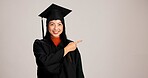 Pointing, graduation and space with portrait of asian woman in studio for success steps, college information or timeline. Show, education and university with person on white background for mockup