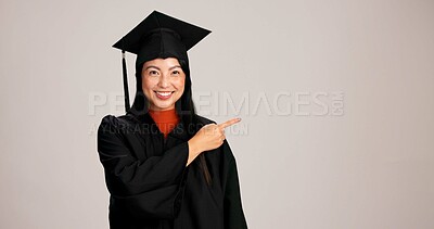 Buy stock photo Pointing, graduation and space with portrait of asian woman in studio for success steps, college information or timeline. Show, education and university with person on white background for mockup