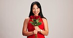 Woman, studio background and smile with rose on portrait for love, care and valentines day celebration in Japan. Japanese person, romance and happy in red dress with flower as anniversary gift