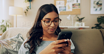 Buy stock photo Woman, phone and relax on sofa with social media, connectivity and reading ebook in home. Girl, student or mobile in living room on study break, streaming service or text message for weekend planning