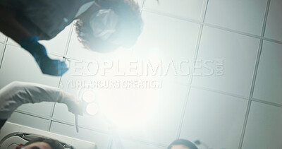 Buy stock photo Dentist, team or surgery below with light for dental hygiene, cleaning or cavity removal at hospital. Lens flare, low angle and medical orthodontist with patient for oral, mouth or gum care exam