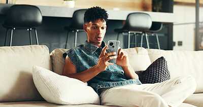 Buy stock photo House, surprise and man on sofa, smartphone and typing with social media, announcement and network. Apartment, person and guy with cellphone, shocked and message to contact, app or email notification
