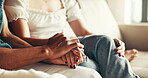 Couple, support and holding hands on sofa with love, empathy and trust in home relationship. People, relax and gesture in living room for care, commitment and encouragement with compassion or loyalty