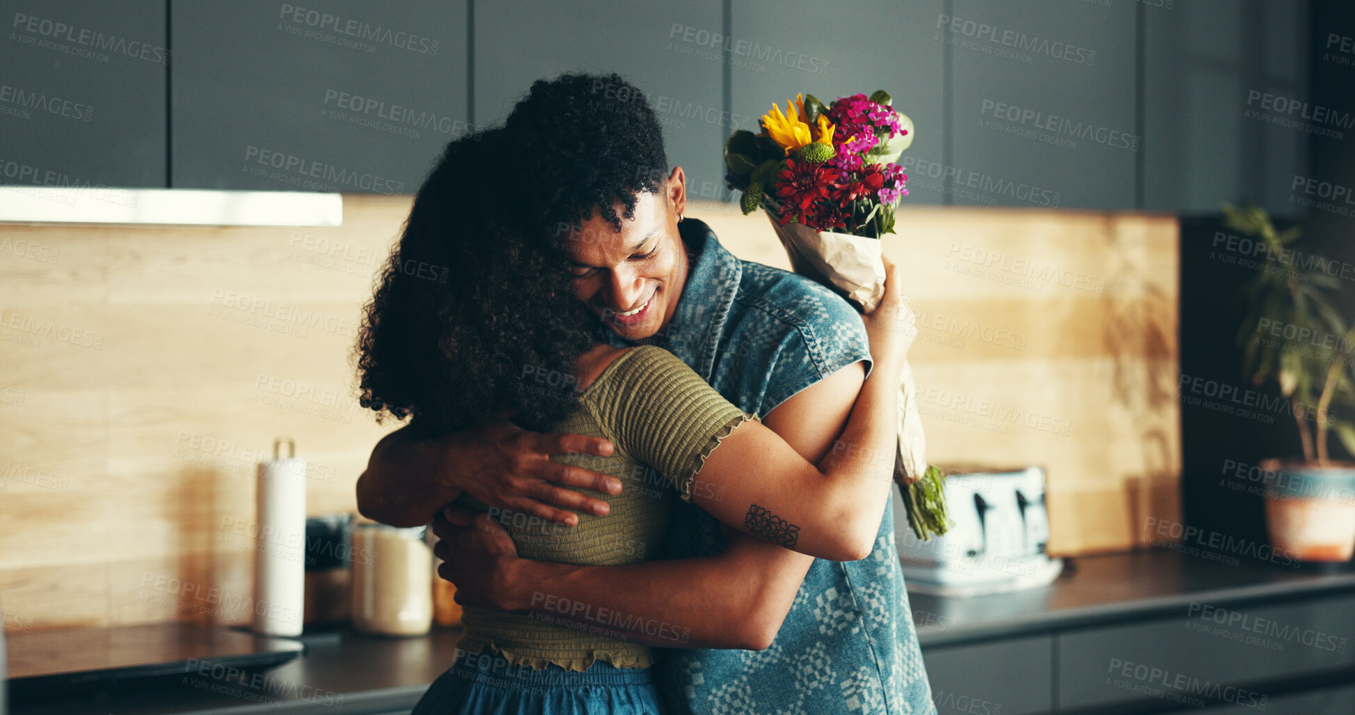 Buy stock photo Love, couple and hug with flowers in kitchen for valentines day, romance and celebration of marriage. Gratitude, people and thank you for floral bouquet with support, commitment and surprise gift