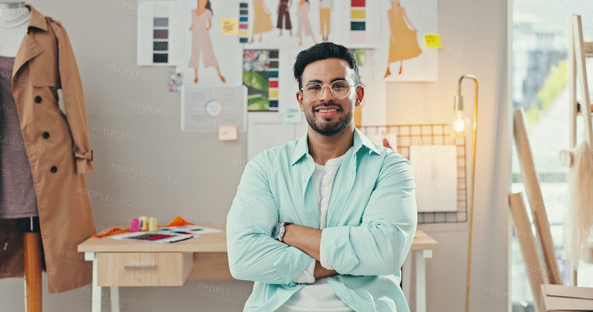 Buy stock photo Arms crossed, creative and portrait of fashion designer man in textile workshop for production. Clothes, glasses and wall with happy style director at desk in office for manufacturing process