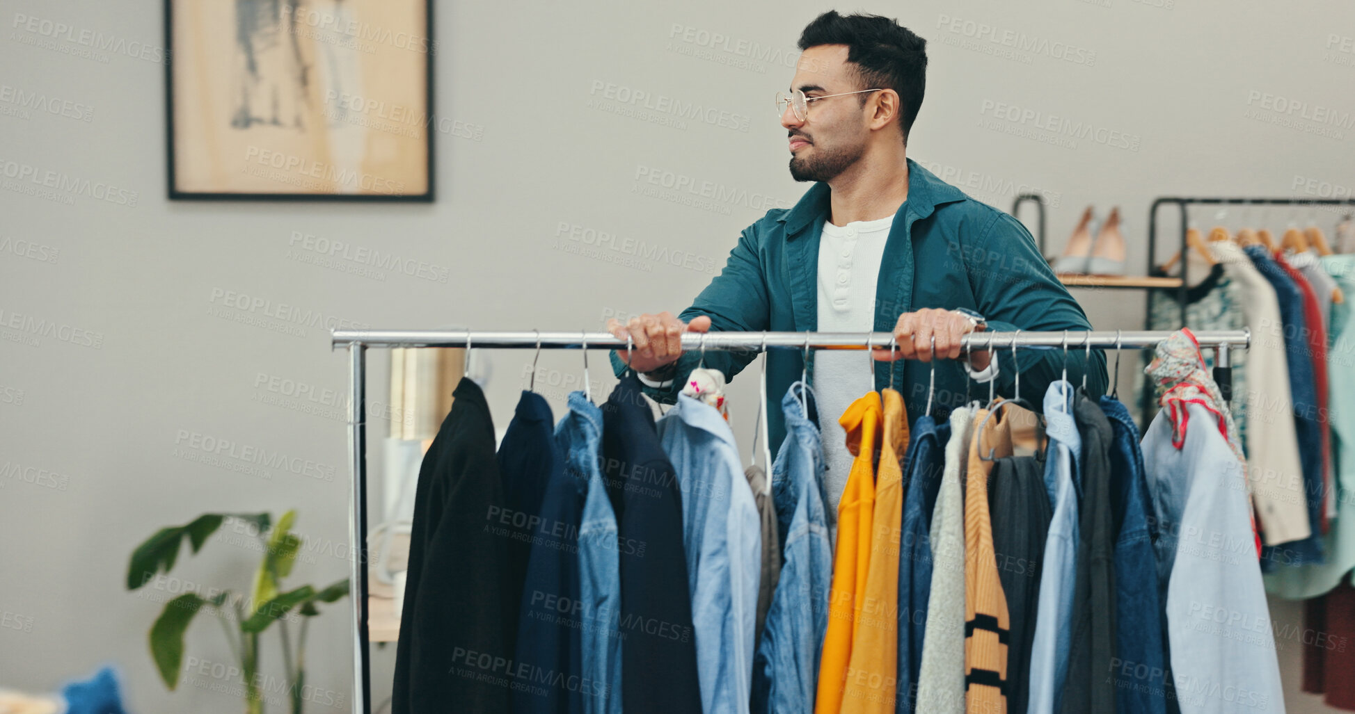 Buy stock photo Clothing rack, creative and wardrobe with fashion designer man in textile workshop for decision. Choice, options and preparation with style director in office for clothes production or manufacturing