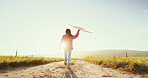 Kid, running outdoor and play with airplane for game, freedom and travel on mockup space. Back, girl and child with toy plane by sky for flight, vacation and sunrise on countryside path for adventure