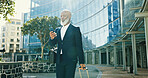 Phone, business and black man with luggage in city for journey, travel schedule or booking flight. Suitcase, walking and mature professional with mobile at building, hotel or trip outdoor on commute