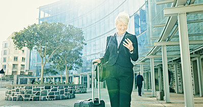 Buy stock photo Phone, business woman and travel with suitcase in city for journey, booking flight or planning schedule. Mobile, trip and mature professional with luggage at building, hotel and happy on commute 