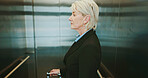 Business, woman and travel with luggage in elevator for leaving hotel, journey to airport or work trip. Mature professional, person and waiting in lift for corporate retreat or exit company building