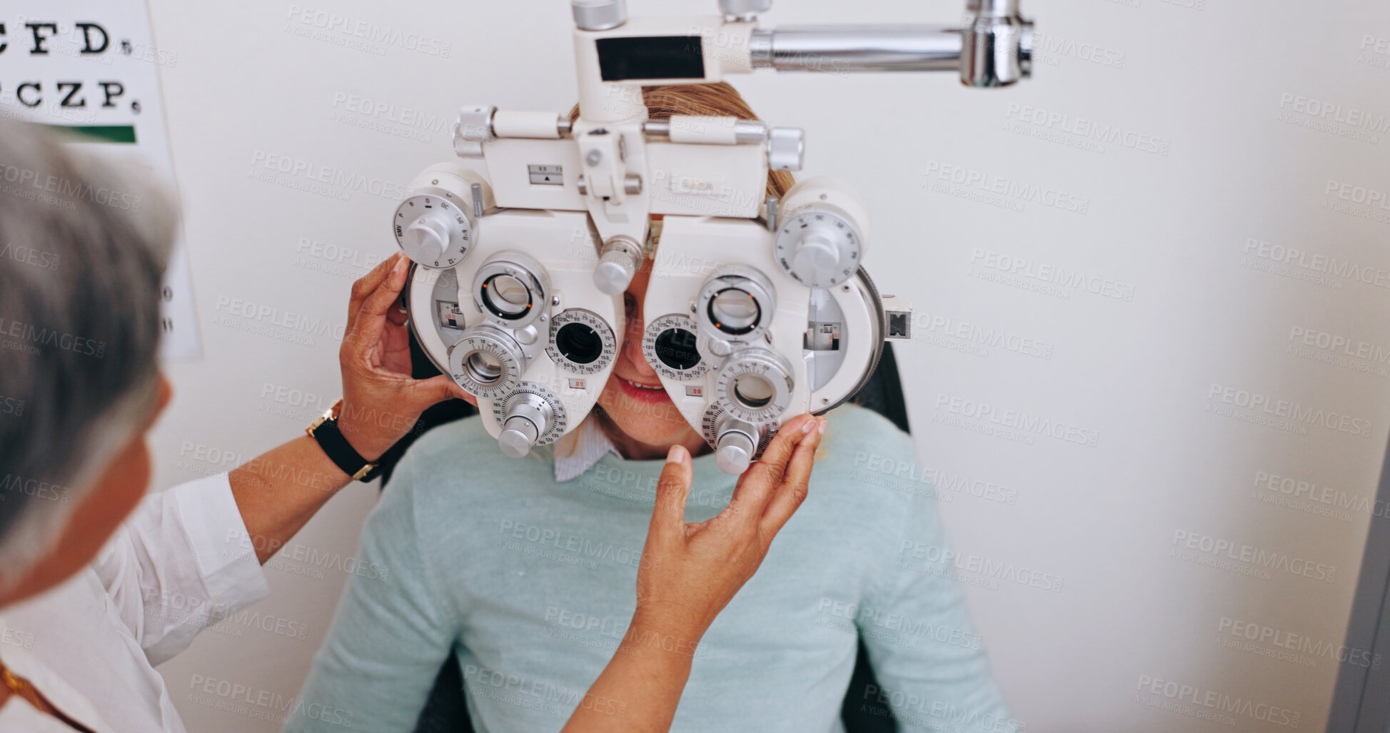 Buy stock photo Doctor, optometry and woman on phoropter for vision, consultation and hands in clinic for health exam. Ophthalmologist, test and patient on machine for eye care, wellness and eyesight correction