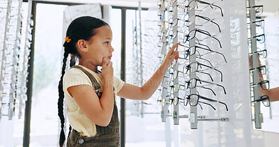Buy stock photo Girl, child and shopping for glasses with choice at optometry clinic for vision, wellness and profile. Kid, thinking and customer with decision for prescription eyewear, sight and frame at store