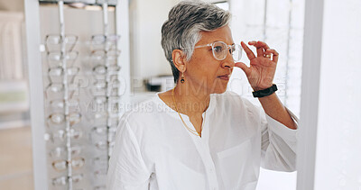 Buy stock photo Mature woman, glasses and check in mirror at clinic for healthy vision, wellness or optometry services. Person, client and customer with decision for prescription eyewear, shopping and frame at store