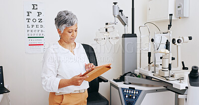 Buy stock photo Mature woman, optometrist and tablet at clinic to check booking for eye test, assessment and services. Person, doctor and reading on touchscreen, app and feedback for medical research at hospital