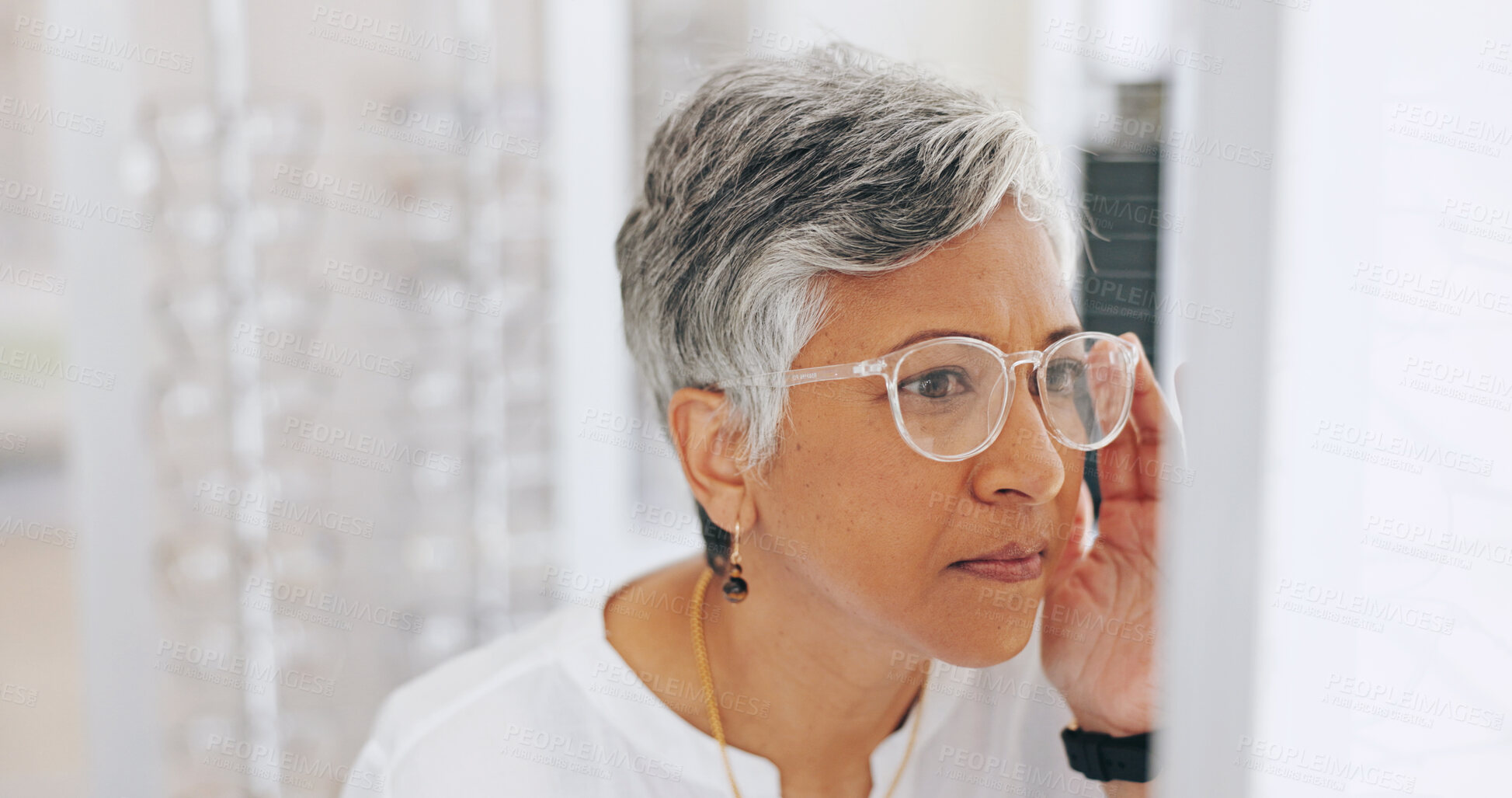 Buy stock photo Mature woman, glasses and choice in mirror at clinic for healthy vision, wellness and optometry services. Person, client and customer with decision for prescription eyewear, sight and frame at store