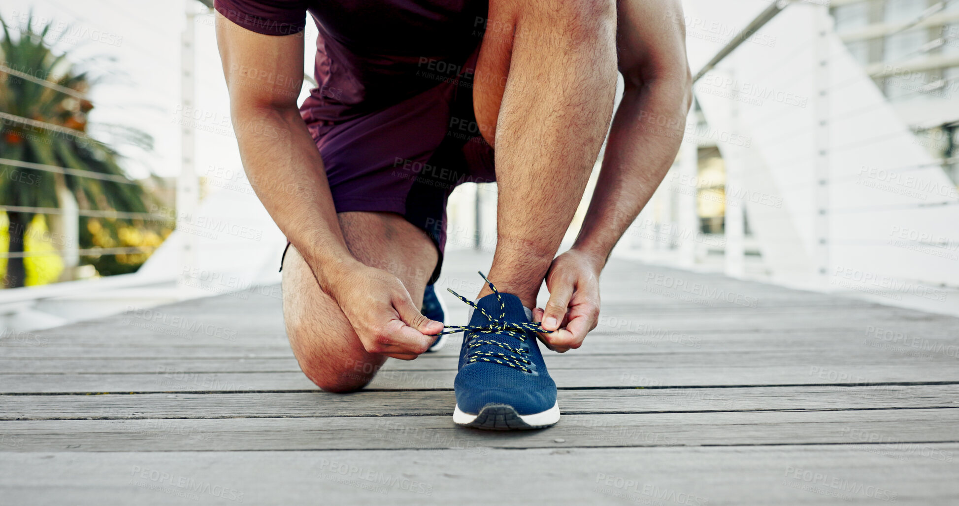 Buy stock photo Man, tying shoes and city athlete for getting ready, running training and outdoor for activity. Male person, fitness preparation and urban bridge for footwear, strong legs and tie laces in town