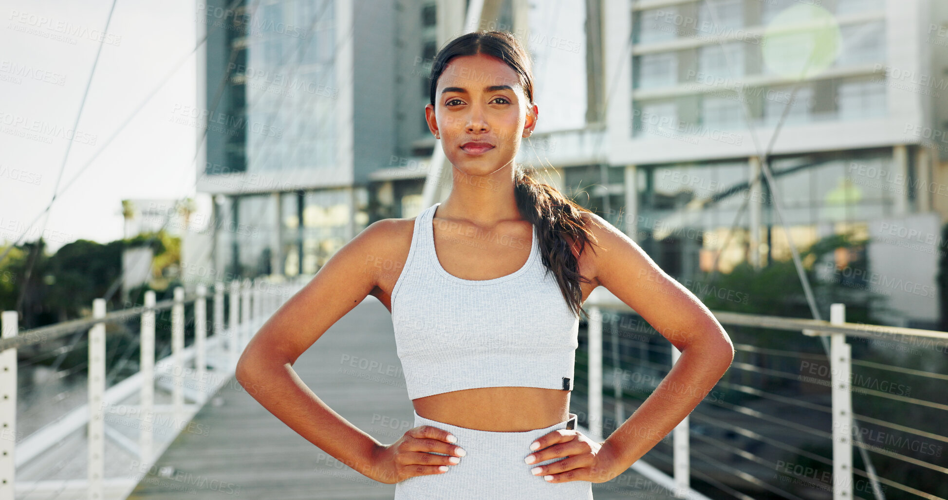Buy stock photo Portrait, training and woman in city, runner and urban town with buildings, lens flare and exercise. Face, healthy athlete and person with confidence, bridge and wellness with workout and fitness