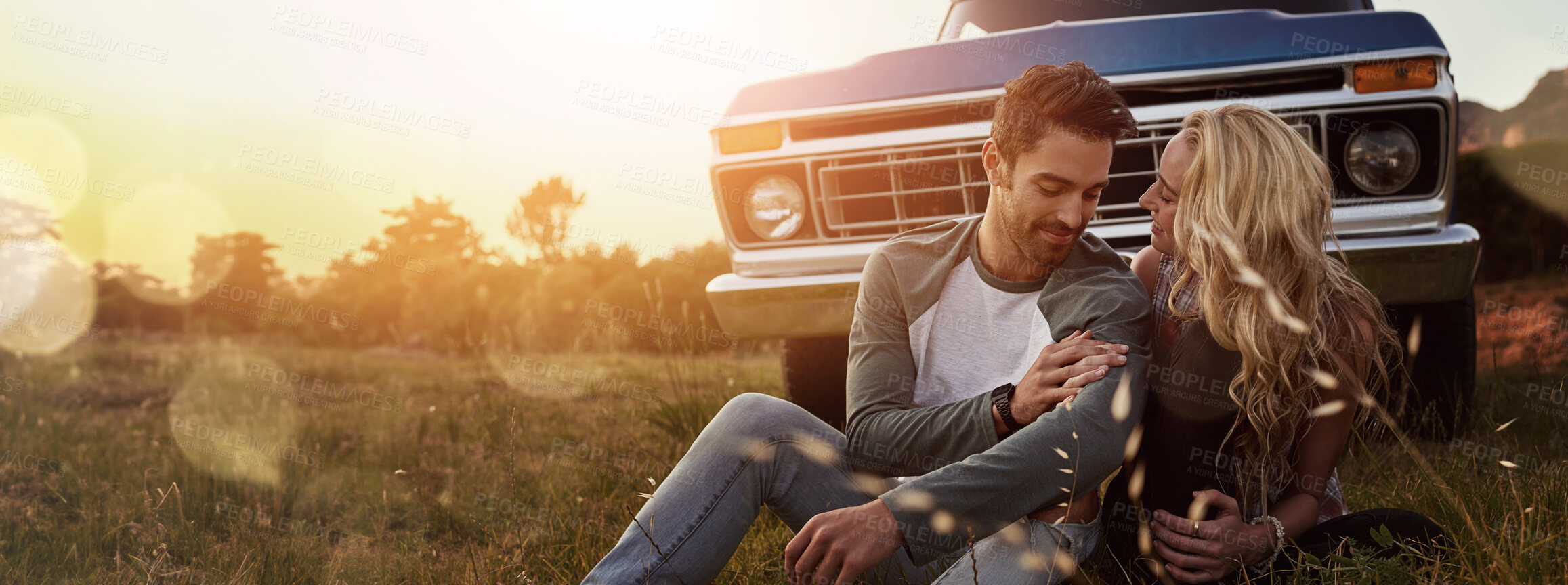 Buy stock photo Relax, nature and couple by car for travel by sunset on vacation, weekend or holiday. Happy, love and young man and woman outdoor in field by vehicle for road trip getaway together in evening.