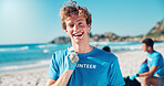 Volunteer, cleaning and portrait of man on beach for collecting dirt, plastic and litter for ocean pollution. Community service, charity and person for environmental care, recycling or climate change