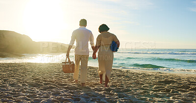 Buy stock photo Basket, holding hands and picnic with couple on beach together for romantic holiday or vacation. Back, love and walking with people on sand at ocean or sea for travel to tropical island paradise