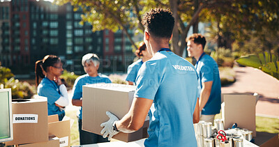 Buy stock photo Box, volunteer team and outdoor for donation, help and back for community care. NGO group, man and charity service with package for distribution, food drive and humanitarian aid with poverty supplies