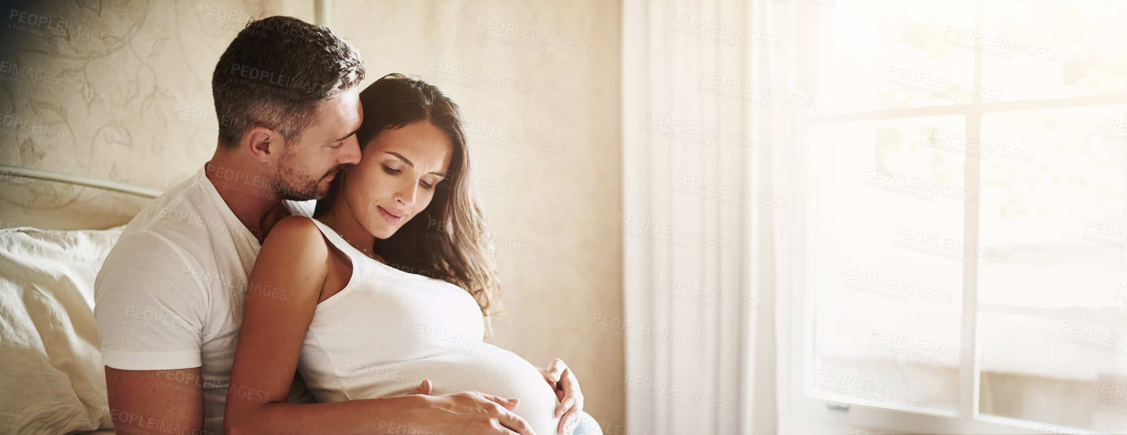 Buy stock photo Connection, pregnancy and couple by window in home with love, bonding and marriage commitment to family. Rest, maternity leave and man embracing pregnant woman for prenatal care relaxing in apartment