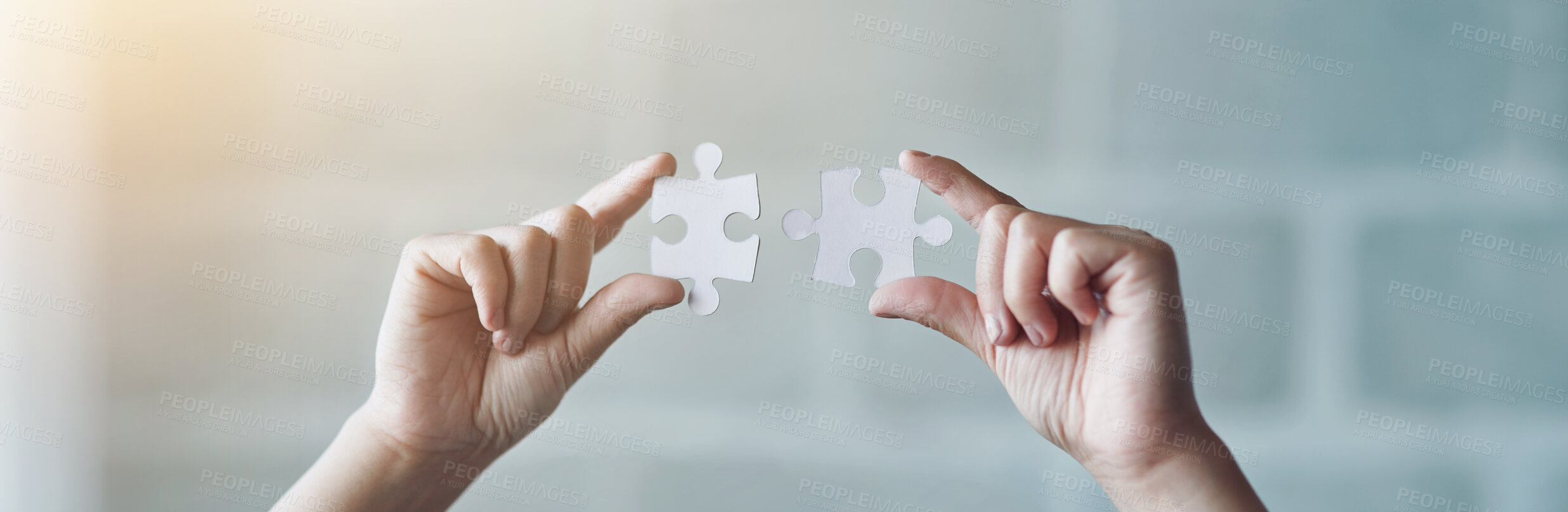 Buy stock photo Hands, banner and person with puzzle by office brick wall for building, development or connection. Planning ideas, innovation and strategy with creative employee holding jigsaw pieces closeup at work