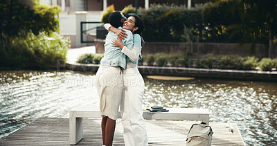 Buy stock photo Woman, students and outdoor with hug for welcome, reunion and support at university campus. Friends, excited and embrace at canal for greeting, bonding and relax on study break at community college