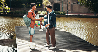 Buy stock photo People, students and campus for shaking hands, outdoor and friends talking on education. Men, academy and support with university project or module, conversation greeting and study at college park