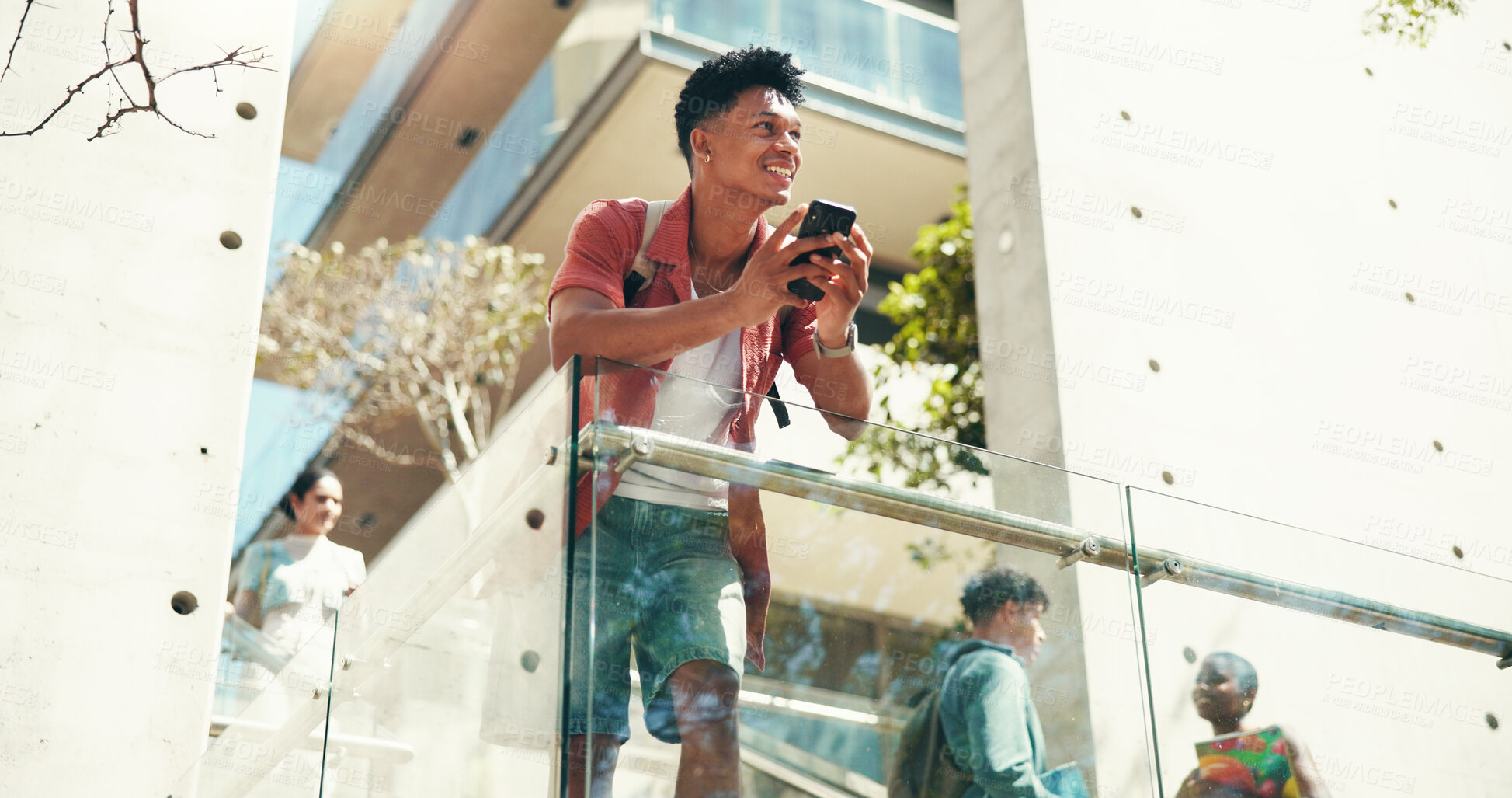 Buy stock photo Man, student and phone on stairs at college, smile and thinking with class schedule with low angle. Person, smartphone and happy with mobile app on steps, texting and social network at university