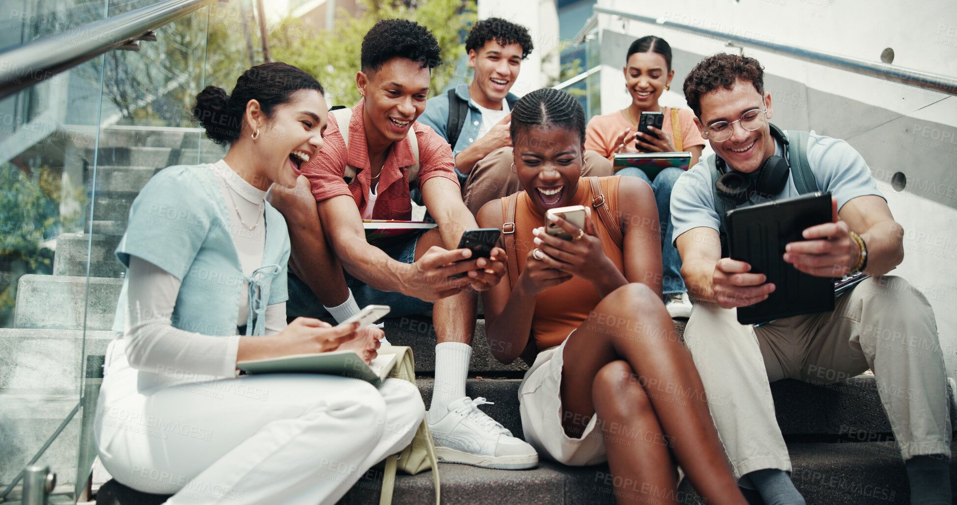 Buy stock photo Students, laugh and tech on stairs at campus, break and share meme with diversity in low angle at university. Friends, people and happy on steps with phone, tablet or streaming comic video at college