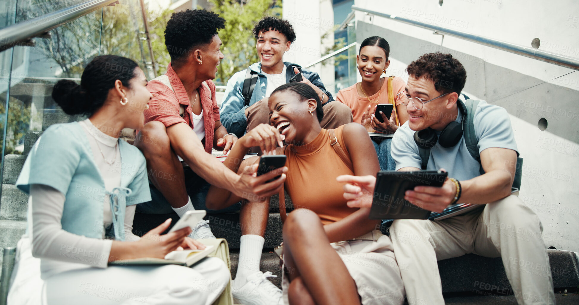 Buy stock photo Students, group and tech on stairs at college, laugh and share meme with diversity in low angle at campus. Friends, people and happy on steps with phone, tablet or streaming comic video at university