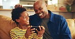 Playing, dad and child with smartphone, home and bonding with video game, laughing and fun for score. House, man and gamer with mobile app in lounge, African and boy with hobby, subscription or break