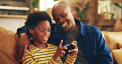 Buy stock photo Fun, dad and child with smartphone, home and bonding with video game, laughing and playing for score. House, man and gamer with mobile app in lounge, African and boy with hobby, subscription or break