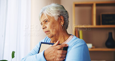 Buy stock photo Senior woman, photo frame and memory in home with grief, thinking and remember loss in living room. Elderly person, broken heart and hugging picture for mourning, nostalgia and lonely in retirement