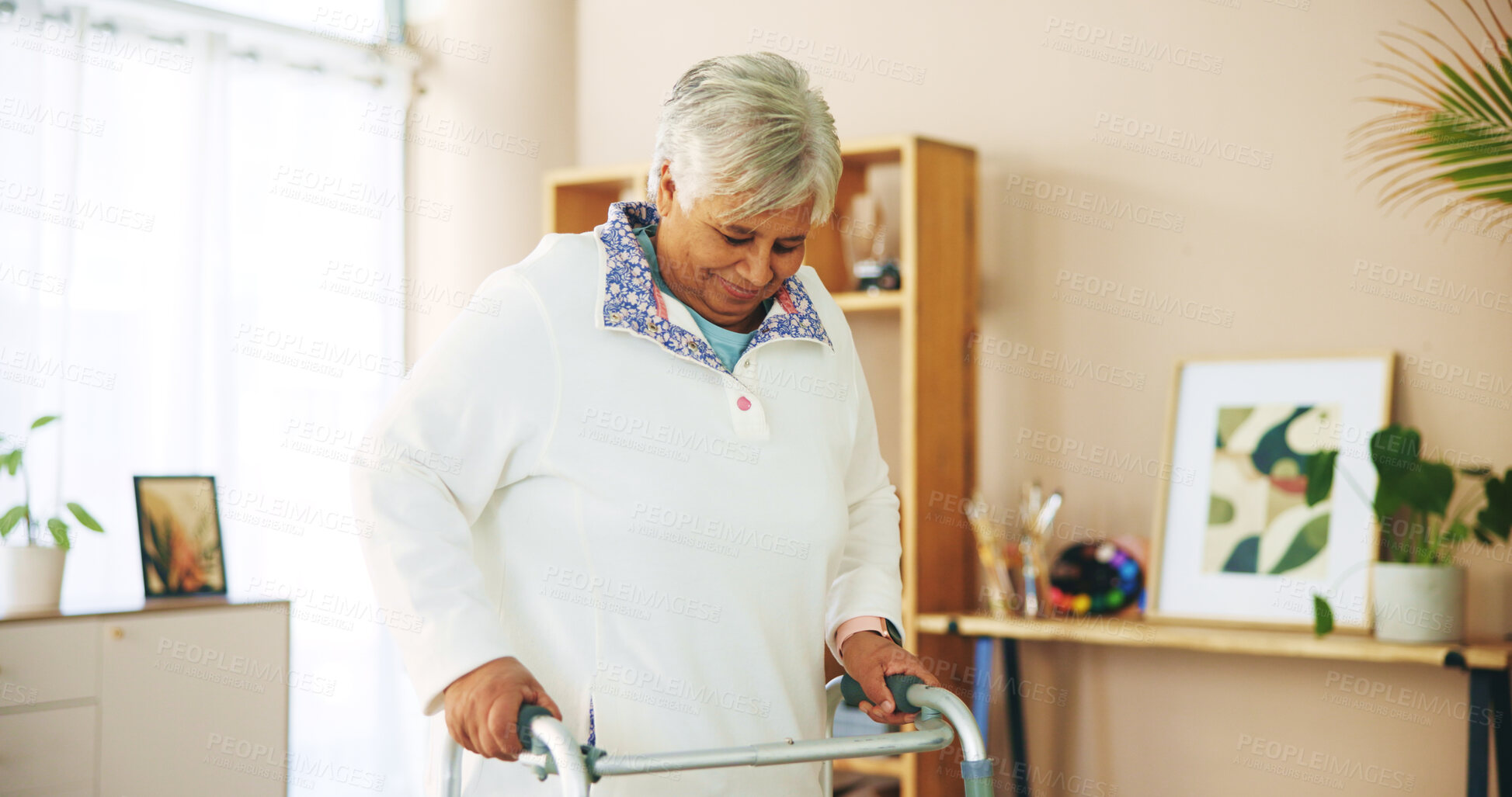 Buy stock photo Elderly woman, walker and happiness at nursing home for care, support and mobility in rehabilitation. Senior, female person with disability and lounge with arthritis, injury and balance as pensioner