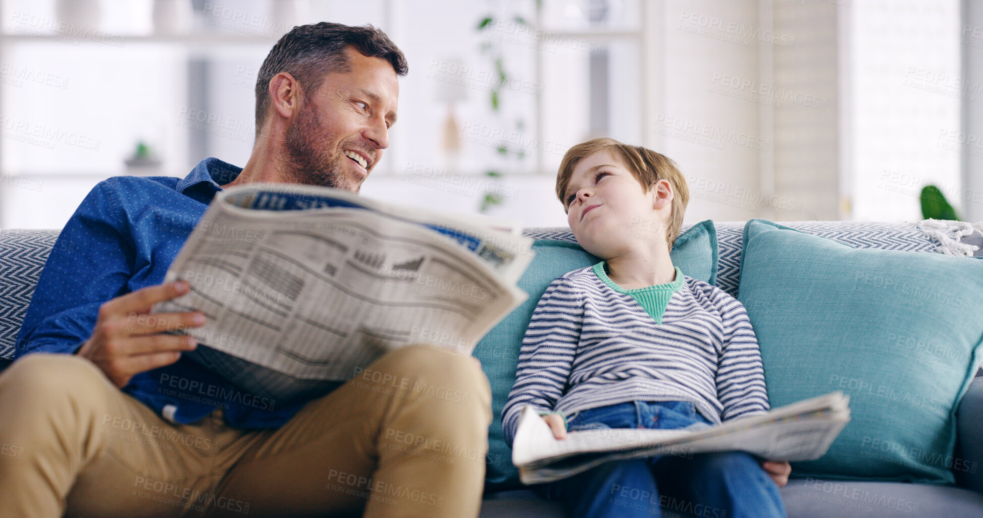 Buy stock photo Dad, boy and newspaper on sofa, happy and reading with bonding, care and talking in family home. Father, child and laugh with headlines, relax and learning with bulletin in living room at apartment