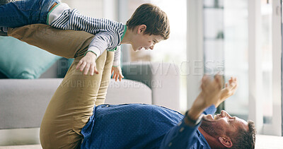 Buy stock photo Dad, boy and airplane on floor in home, game and playful with smile, knees and bonding with love in lounge. Father, child and lifting for plane, flight or excited with laugh on carpet in family house