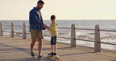 Buy stock photo Dad, son and outdoor for learning skateboard, adventure and sea vacation for bonding with father. Boy, child and papa for support in relationship, helping kid and promenade for love or care on trip