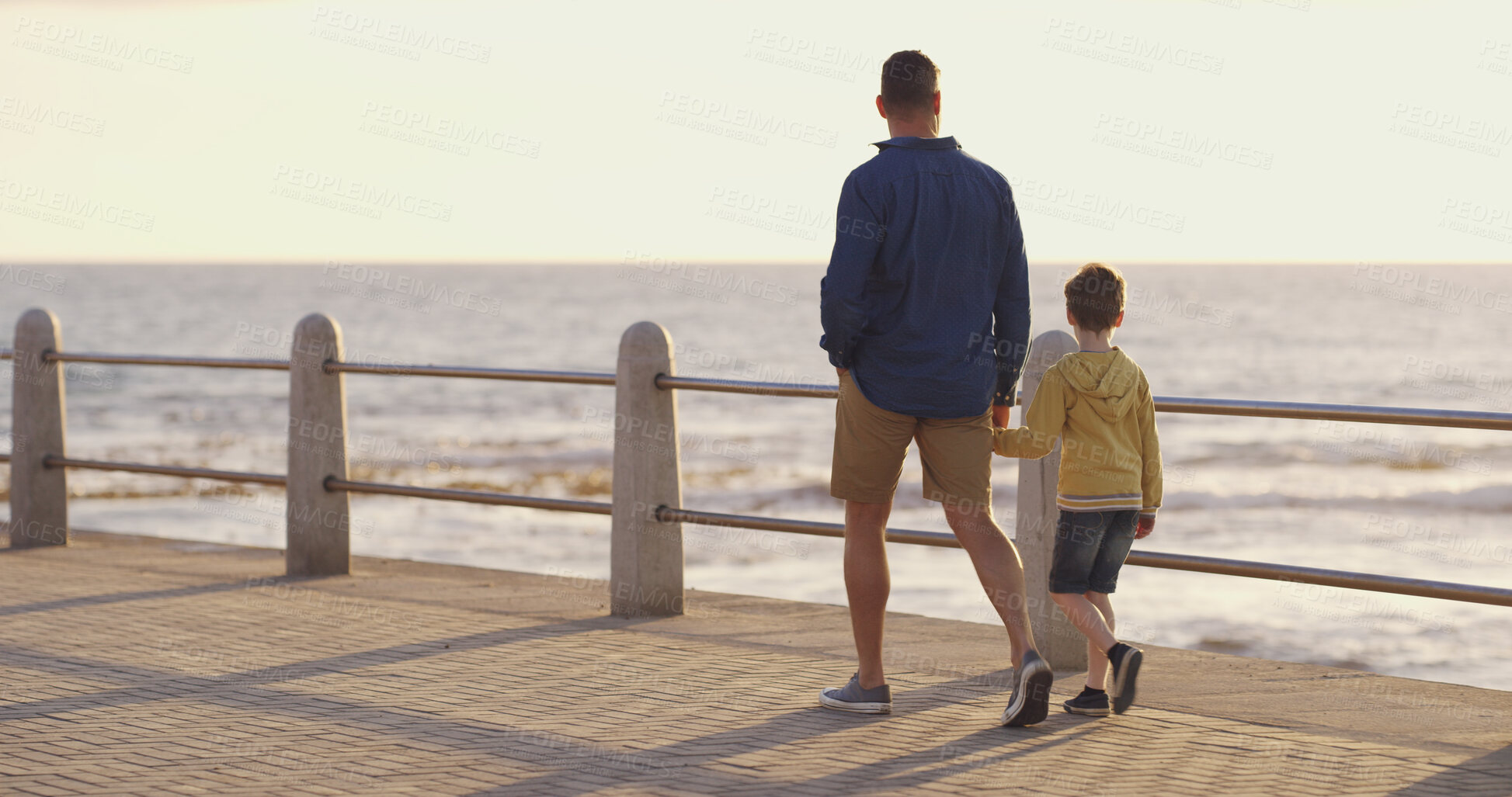 Buy stock photo Dad, son and holding hands at beach on holiday, walking and outdoor for bonding with father. Back, child and papa for vacation security in relationship, together and ocean for love or care on trip